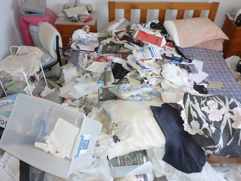 Hoarding house with rubbish in a bedroom